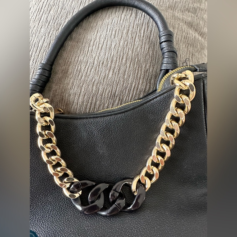 Small handle bag with chain accent . Black and gold